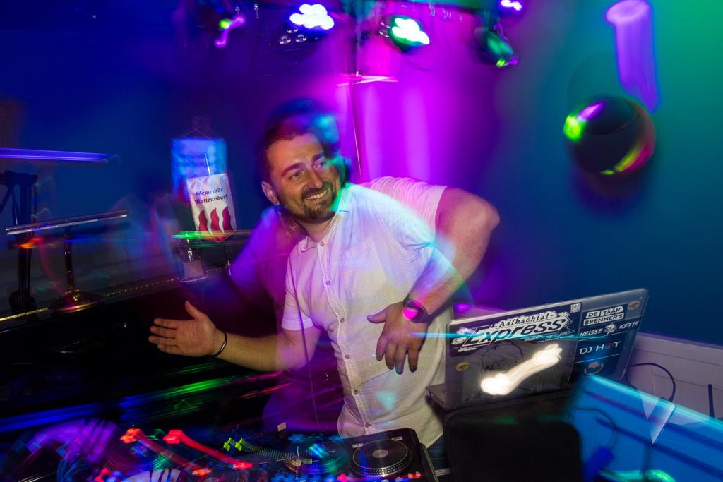 DJ Hot in Aktion mit bunten Lichteffekten auf einer Party